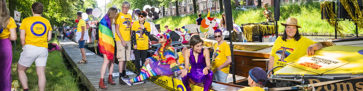 Personen van Stichting NNID, de Nederlandse Organisatie voor Seksediversiteit, voor en op hun boot op de Utrecht Pride 2023.