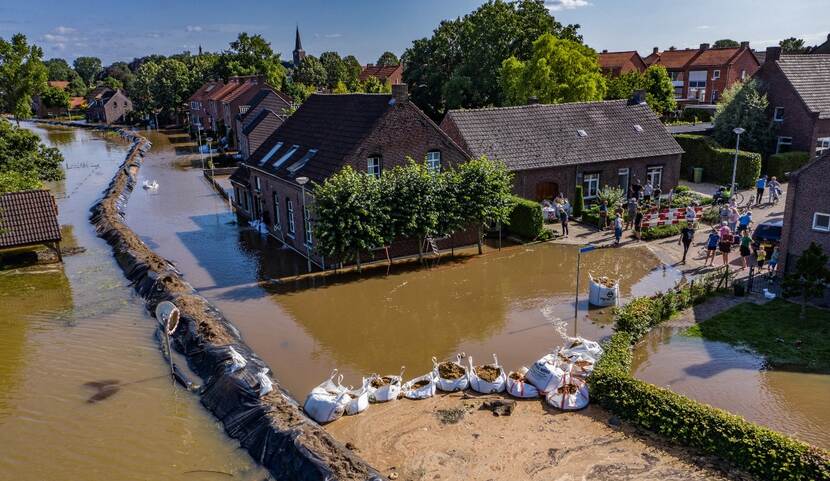 Het Limburgse plaatsje Horn is overstroomd in juli 2021, inwoners proberen water tevergeefs te keren met zandzakken